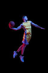 Portrait of sportive man, professional basketball player playing basketball isolated on dark background in neon light. Achievements, sport career, motion concepts. © master1305