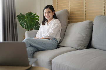 Young beautiful woman is working with her computer at home.