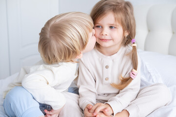 cute kid blonde boy kissing little girl with long hair