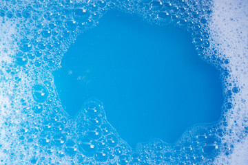 Detergent foam bubble on blue background.