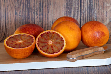 cut blood oranges isolated on a wooden background