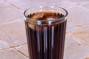 glass of cola with ice cubes isolated on a table