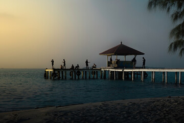 Silhouette on the sea with golden sky and clouds before sunset from south of Indonesia. 