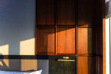 A beam of sunset sunlight hits a cabinet in a bedroom