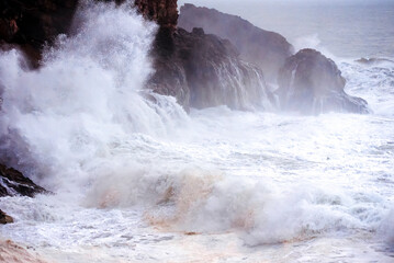 Big waves crashing on the rocks during a storm