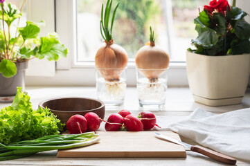 Fresh spring vegetables on a wooden cutting board by the window. Healthy food for you and your family.Cook at home.