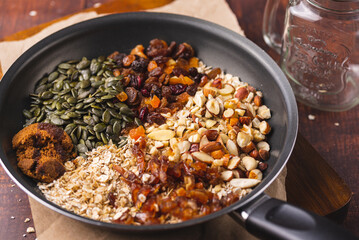 Ingredients of a Granola Oatmeal, Pecans, Nuts, Oats, Dates, Pine Nut on a Skillet Pan
