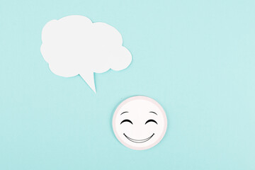 Smiling face with a speech bubble, rating, positive feedback, customer experience, having a message, talking cloud, blue colored background, copy space for text