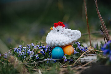 knitted hen sits on easter eggs