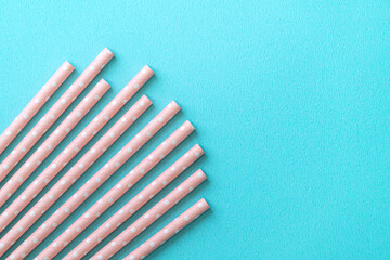 Biodegradable paper straw set on blue table background.