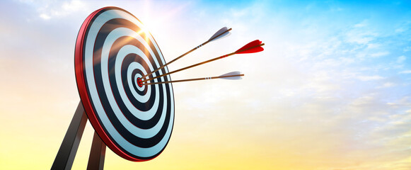 Achieve goals - dart board with arrows in the evening sun - 497719038