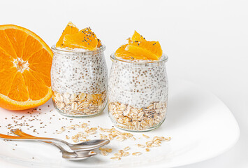 Chia seed pudding with orange and oats on white background. Superfood concept.