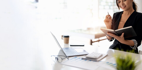 Closes up accountant asian woman hand is writing on notepad with pen in office. business accounting concept.