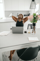 Black African businesswoman relaxing, stretching, working from home