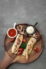 grilled whole squid with aioli and spicy sauce in spanish restaurant