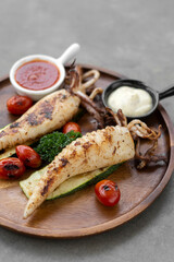 grilled whole squid with aioli and spicy sauce in spanish restaurant
