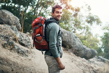 Lets go on a adventure. Portrait of a cheerful young man wearing a backpack and ready to hike up a mountain. - obrazy, fototapety, plakaty