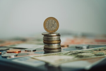stack of euro coins with one coin on top with blurred background