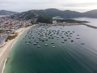 Anjos beach with many boats and houses in Arraial do Cabo, Rio de Janeiro, Brazil. Aerial drone view.