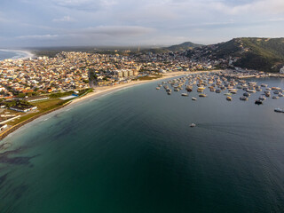 Anjos beach with many boats and houses in Arraial do Cabo, Rio de Janeiro, Brazil. Aerial drone view.