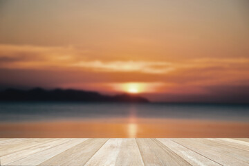 Fototapeta na wymiar Empty top wooden table on soft focos blurred beautiful sunset at sea for background