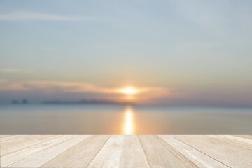 Fototapeta na wymiar Empty top wooden table on soft focus blurred beautiful sunset at sea for background
