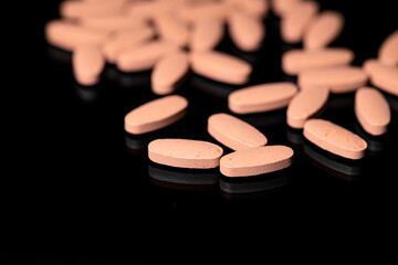 Close up of Multi Vitamin tablet on a reflective black background