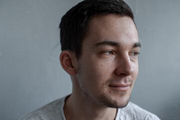 Fototapeta premium Young man struggling with acne on his face caring for his skin pushes acne