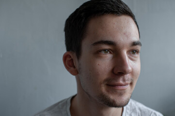 Fototapeta premium Young man struggling with acne on his face caring for his skin pushes acne