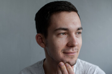 Fototapeta premium Young man struggling with acne on his face caring for his skin pushes acne