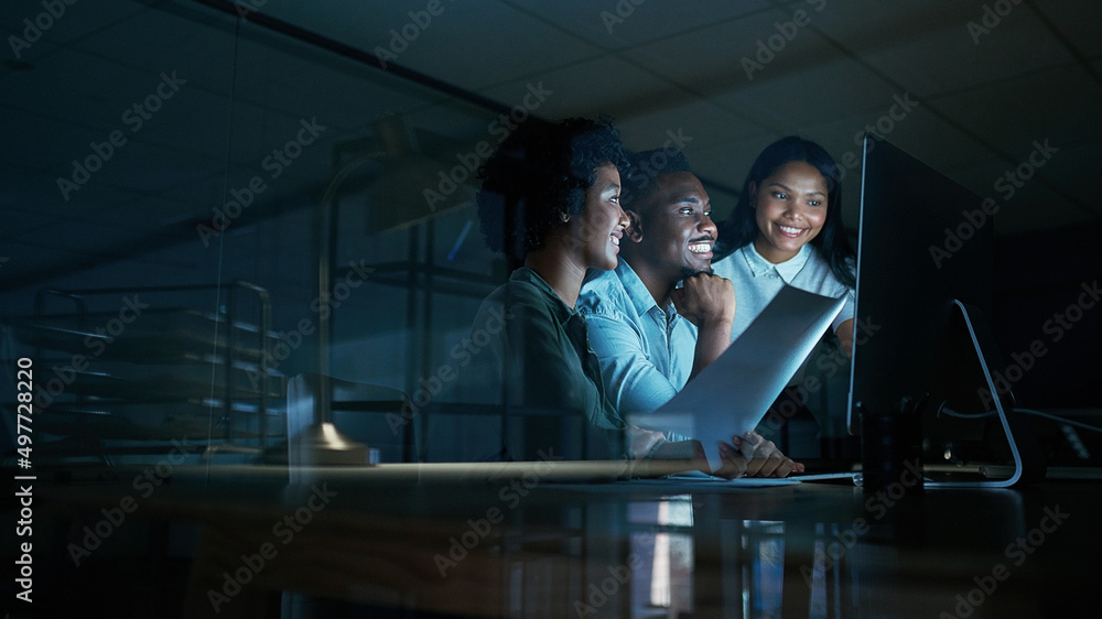 Poster Doing what matters makes things happen. Shot of a group of young businesspeople using a computer together during a late night at work.