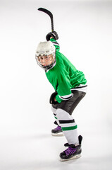 Youth hockey player taking a slap shot to score a goal