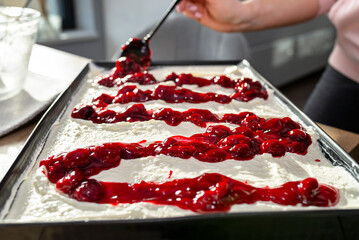 Pour the cherry sauce over the cheesecake with a teaspoon, finishing the preparation of the...