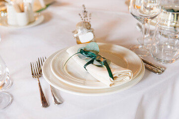 table setting elements in the restaurant, white tablecloth, white plate, white napkin