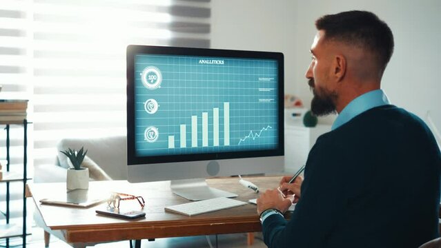Businessman researches the market by looking at a computer with charts and diagrams