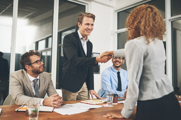 Congratulations and welcome to the team. Shot of businesspeople shaking hands during a job interview in an office.