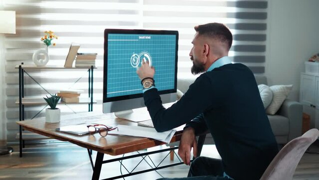 Smart home, application on the computer. Man turns on the automation of the smart home using app on the computer