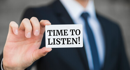 Businessman presenting 'Time to listen' word on white card