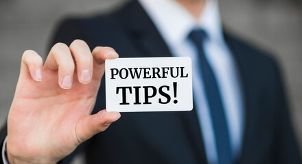 Businessman presenting 'Powerful tips' word on white card