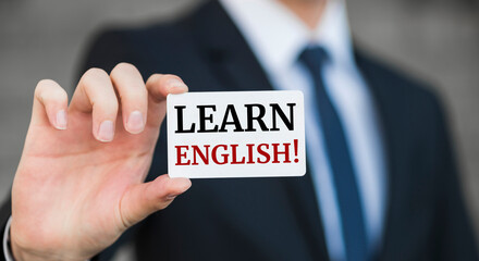 Businessman presenting 'Learn English' word on white card