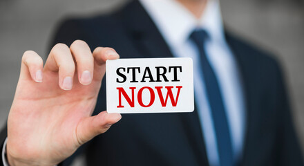 Businessman presenting 'Start now' word on white card