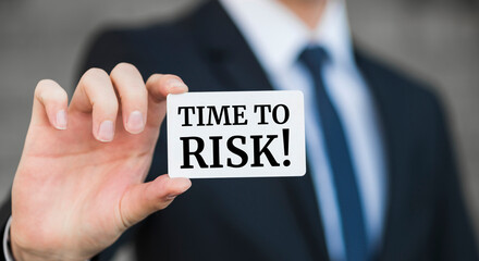 Businessman presenting 'Time to risk' word on white card