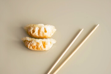 Fried gyoza dumpling and bamboo chopsticks, minimal style. Asian food.