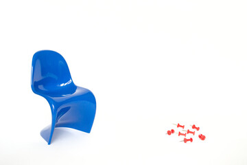 Blue chair with red paper pins on a white background. Hemorrhoid Concept