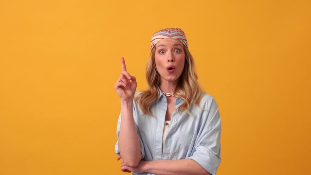 Smiling blonde woman hippie having an idea at the camera in the orange studio