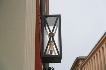 Vintage street lamp on the wall of an old house with raindrops on the glass in Krakow, Poland