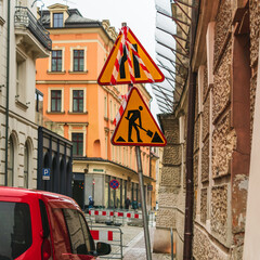 Road signs about the danger zone of the road and carrying out repair work on a rainy day in the old...