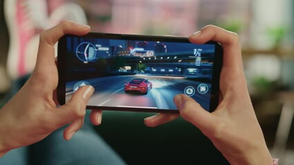 Female is Relaxing on a Couch at Home, Playing an Interactive Racing Drift Video Game on Her Smartphone. Gamer Lies on a Sofa in Living Room. Close Up POV Footage of Mobile Device Screen.
