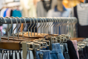 Fototapeta premium Close up of Clothes are hung on hangers at fashion store.