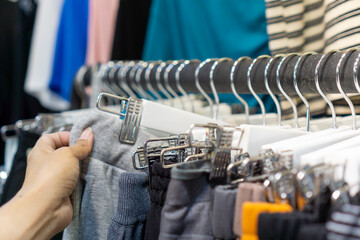 Woman's hand shopping for clothes at clothes store.